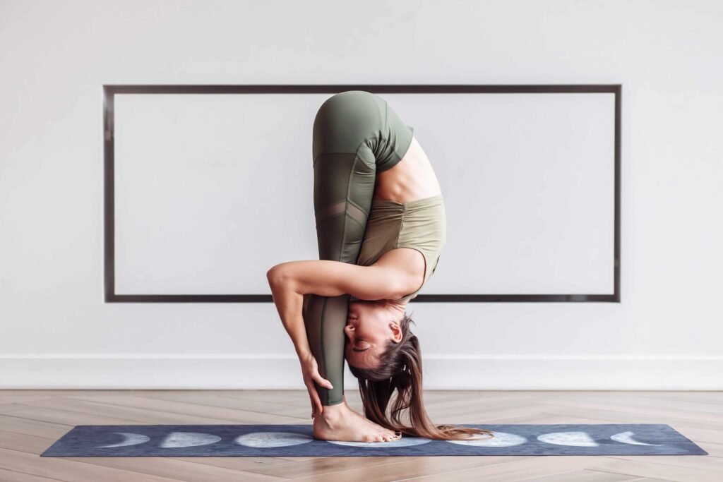 flexible, slim young woman acrobat head practicing effective yoga