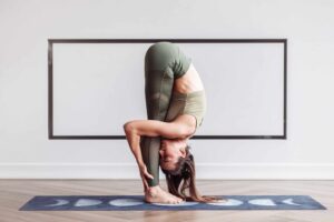 flexible, slim young woman acrobat head practicing effective yoga