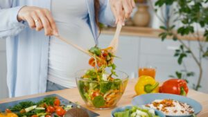 Pregnant woman preparing vegetable for health and fertility diet