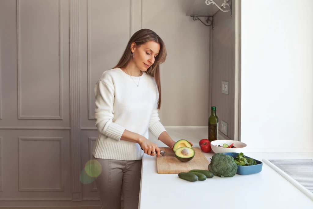 Woman preparing vegetables in kitchen.